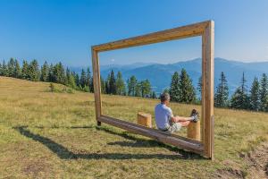 a man sitting on a bench in front of a mirror at Naturoase Appartements Mirnock in Afritz