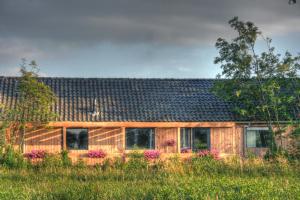 a wooden house in the middle of a field at B&B de Onlanden in Eelderwolde