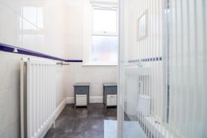 a bathroom with two trash cans and a window at Pebbles guest house room 18 in Southampton