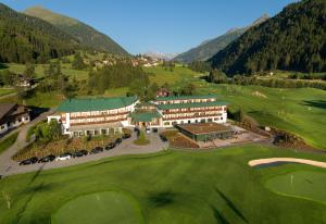 z powietrza widok na hotel i pole golfowe w obiekcie Defereggental Hotel & Resort w mieście Sankt Veit in Defereggen
