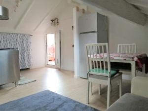 Habitación con mesa, silla y nevera. en Maison Mirt, en Bolonia