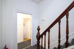 a hallway with stairs and a white wall at Pebbles guest house room 18 in Southampton