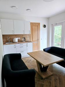 een keuken met een houten tafel en 2 stoelen bij Apartmens LORETA in Šventoji