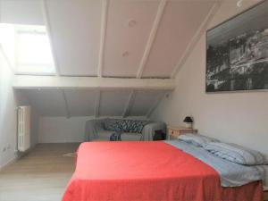 1 dormitorio con cama roja y sofá en Maison Mirt, en Bolonia