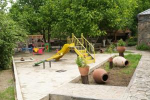 a playground with a yellow slide in a park at Rati's Oda in Aspindza