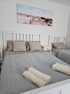 een slaapkamer met 2 bedden en een foto van een pier bij Apartmens LORETA in Šventoji