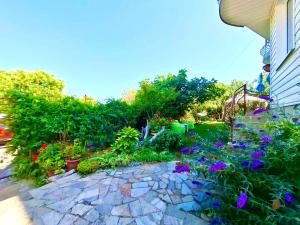 a garden with flowers and plants on a patio at Къща за гости Прохлада in Sinemorets