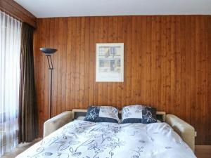 a bed in a room with a wooden wall at Studio Greppon 110 by Interhome in Les Collons