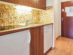 a kitchen with a sink and wooden cabinets at Studio Greppon 110 by Interhome in Les Collons