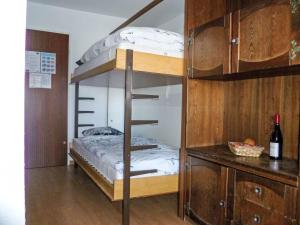 a bunk bed in a room with a bottle of wine at Studio Greppon 110 by Interhome in Les Collons