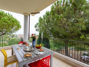 una mesa con comida en un balcón con árboles en Apartment Michela-3 by Interhome, en Pineto