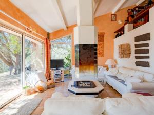a living room with white furniture and a large window at Holiday Home La Sacherie de l'Autourière by Interhome in La Garde-Freinet