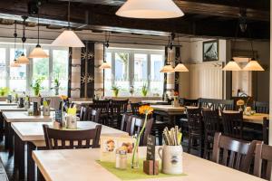 - une salle à manger avec des tables, des chaises et des fenêtres dans l'établissement Gasthof Bögl, à Hilpoltstein