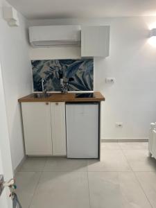 a kitchen with white cabinets and a sink at Casa mia MadamA in Gaeta