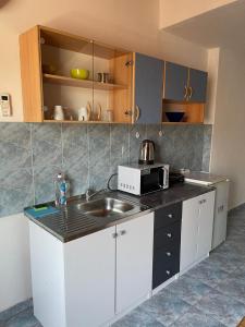 a kitchen with a sink and a microwave at Roman Arch- low budget doublebed room in top center in Pula