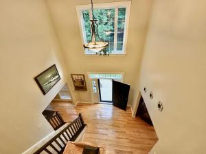 a living room with a staircase and a chandelier at Redbud Retreat in Centerville