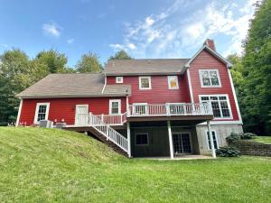 a red house with a deck on a hill at Redbud Retreat in Centerville