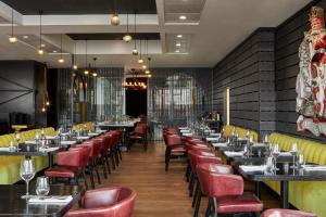 a dining room with tables and red chairs at Sea Containers London in London