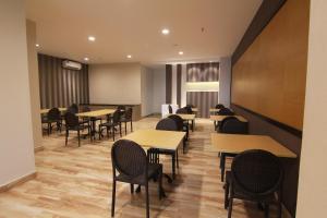 a dining room with tables and chairs in a room at Genio Hotel Manado in Manado