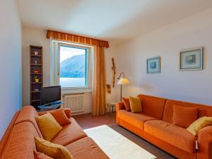 sala de estar con sofá naranja y ventana en Apartment Lago e Sole by Interhome, en Cremia