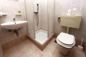a bathroom with a shower and a toilet and a sink at Apartments in Beautiful Split in Podstrana +18 photos