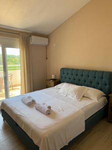 a bedroom with a large bed with towels on it at Sunrise house apartments in Ulcinj