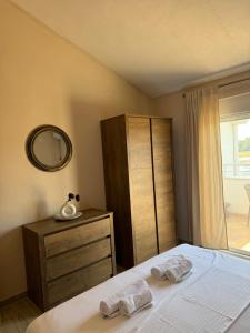 a bedroom with a bed and a dresser and a mirror at Sunrise house apartments in Ulcinj