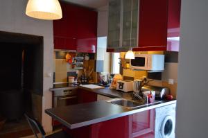 cocina con armarios rojos, fregadero y lavavajillas en Casa do Centro, en Abrantes
