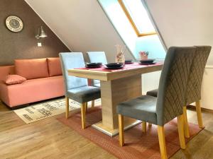a dining room table with two chairs and a couch at KisPagony Apartman in Kaposvár