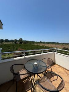 a glass table and two chairs on a balcony at Sunrise house apartments in Ulcinj
