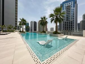 a swimming pool with two chairs on the roof of a building at Trophy - Elevated Living in Luxurious Business Bay Loft in Dubai