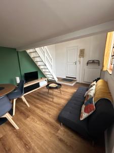 ルーアンにあるCharmant Duplex Rouen Centreのソファと階段のあるリビングルーム