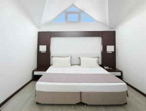a bedroom with a large bed and a window at Arora Hotel in Kusadası