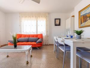ein Wohnzimmer mit einem orangenen Sofa und einem Tisch in der Unterkunft Apartment Cesar by Interhome in Cunit + 19 Fotos