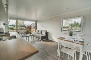 a kitchen and living room with a table and a couch at Lawendowy Zakątek 3 domek z balią in Sominy