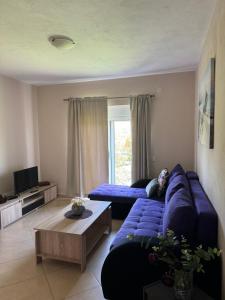 a living room with a blue couch and a table at Sunrise house apartments in Ulcinj
