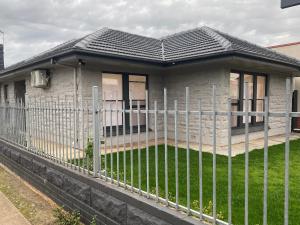 a house with a fence in front of it at Beautiful 3 Bedrooms BNB between Airport and Sea in Cheltenham