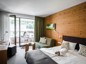 キスレックにあるHofgut Farnyのベッドと椅子のあるホテルの部屋 +29枚の写真