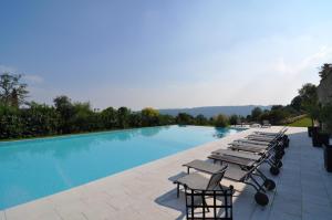 - une rangée de chaises longues à côté de la piscine dans l'établissement Villa Maria, à Salò