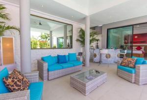 a living room with blue couches and a table at Villa Tropical Cocoon in Koh Samui  +68 photos