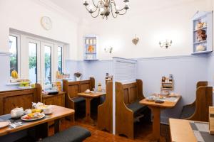 a restaurant with wooden tables and chairs and a chandelier at The Courtyard Guest House in Great Yarmouth