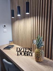 Una piña encima de un escritorio de madera. en Apartament Lux Lemon, en Jelenia Góra