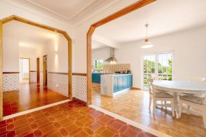 a dining room and kitchen with a table and chairs at GuestReady - Casa de Nazaré da Galileia in Quinta do Anjo +27 photos
