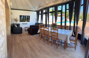 une salle à manger avec une table, des chaises et un canapé dans l'établissement Villa Monbazillac, vue exceptionnelle, piscine, jacuzzi 10-12 pax, à Monbazillac