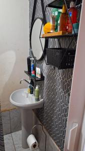 a bathroom with a sink and a mirror at Refrigerado Quarto sala cozinha e sacada in Cuiabá
