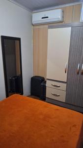 a bedroom with a bed and a dresser and a mirror at Refrigerado Quarto sala cozinha e sacada in Cuiabá