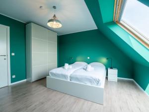 a bedroom with green walls and a white bed at Apartment Parklane-3 by Interhome in Bredene