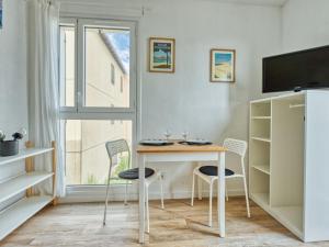 ein Esszimmer mit Tisch und Stühlen und einem Fenster in der Unterkunft Studio Les Terrasses de l'Atlantique-8 by Interhome in Lacanau-Océan + 24 Fotos