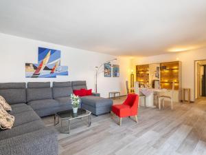 a living room with a couch and a red chair at Apartment Port de la Gavine I-3 by Interhome in Hyères