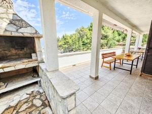 een patio met een stenen open haard en een tafel bij Apartment Octopus-5 by Interhome in Bogomolje
